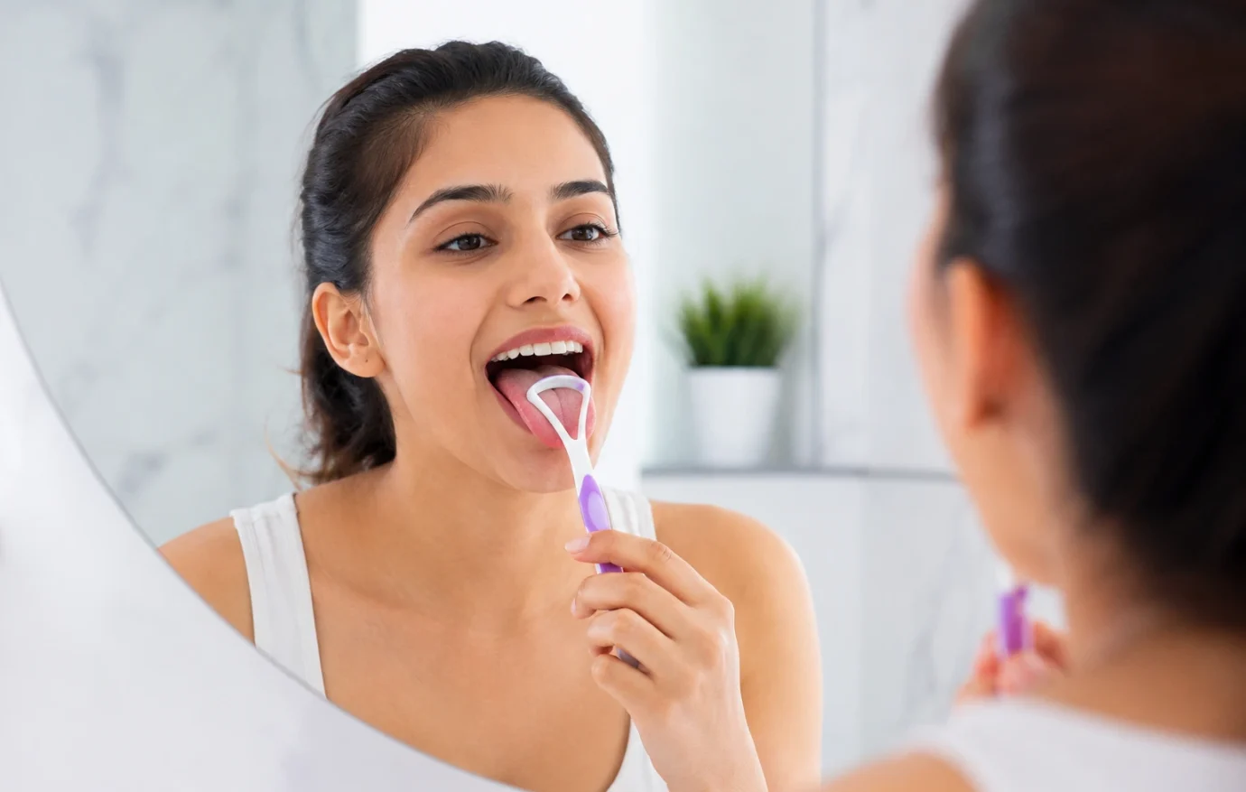 The Importance of Tongue Cleaning for Better Oral Health Person using a tongue cleaner during oral hygiene routine at dental clinic consultation